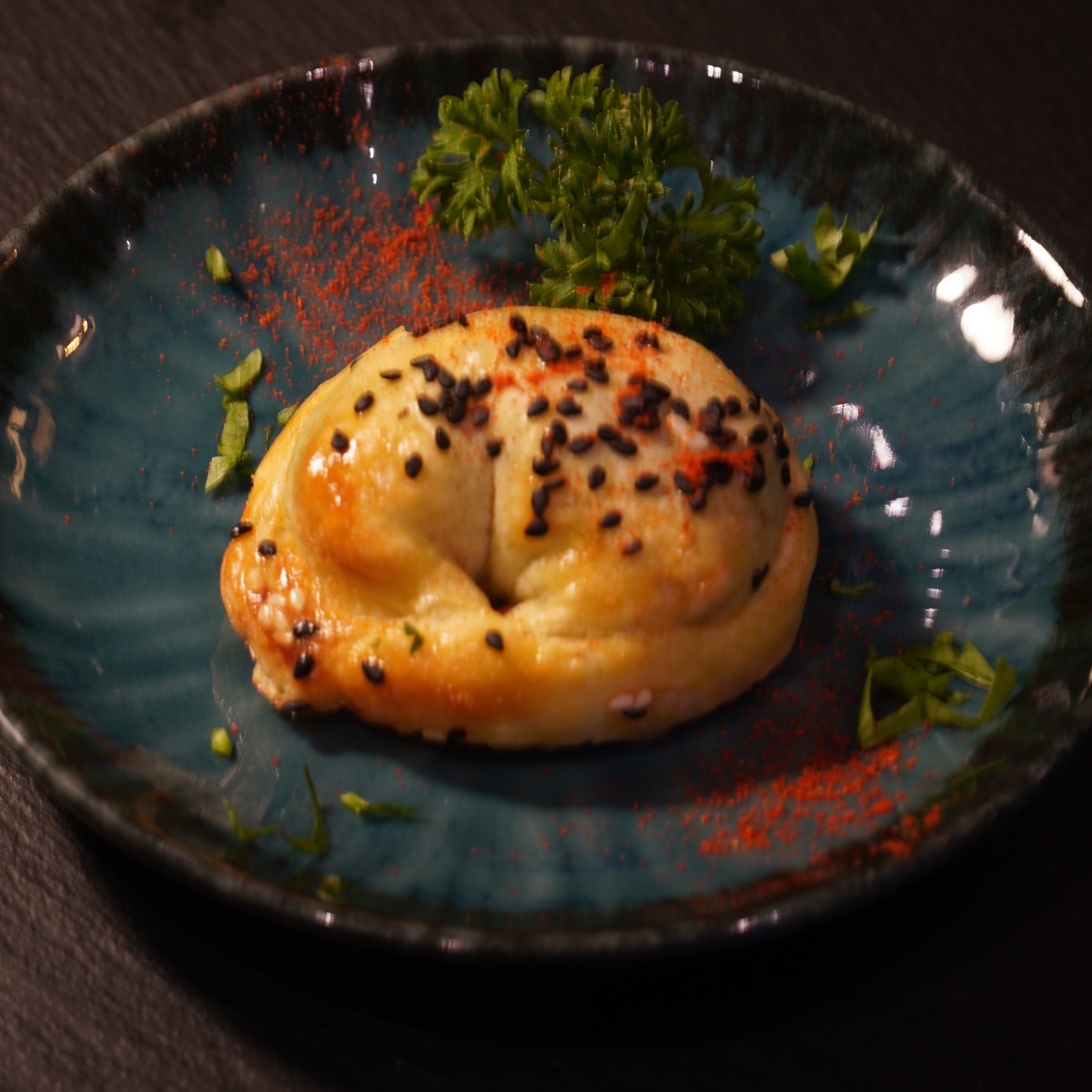 Empanada maison dorée, parsemée de graines et de paprika