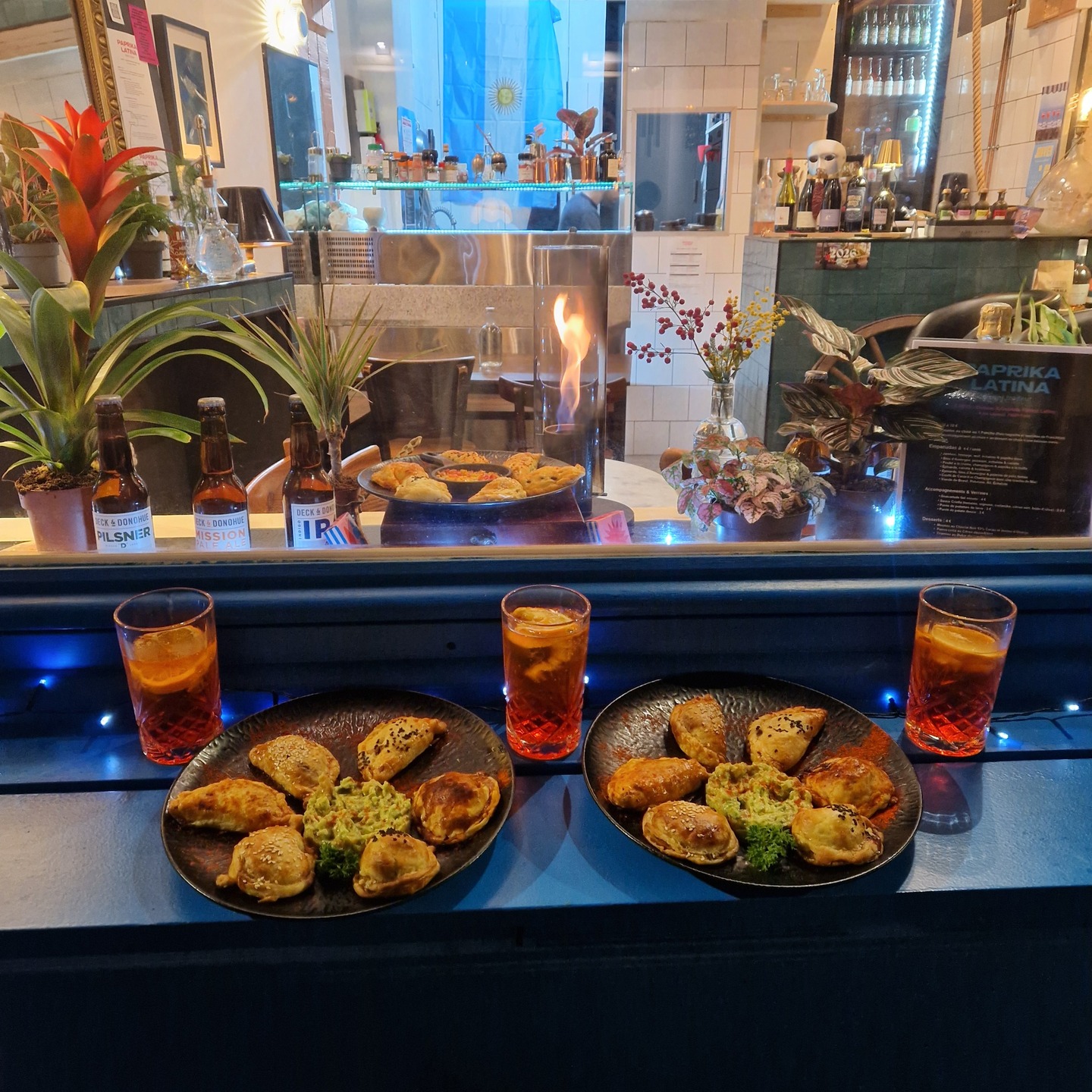 Vitrine de Paprika Latina : plateaux d'empanadas et cocktails